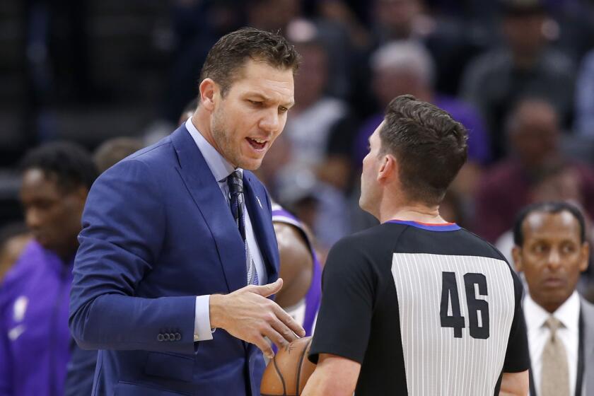 Sacramento Kings coach Luke Walton, talks with referee Ben Taylor at the end of the first quarter of the team's NBA basketball game against the Charlotte Hornets in Sacramento, Calif., Wednesday, Oct. 30, 2019. (AP Photo/Rich Pedroncelli)