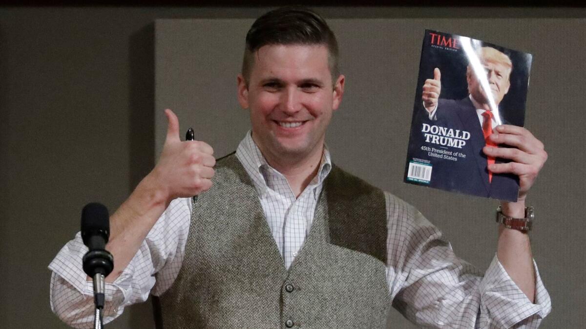 Richard Spencer, who leads a movement that mixes racism, white nationalism and populism, holds up a magazine cover showing President-elect Donald Trump before signing it for a supporter in College Station, Texas on Dec. 6.