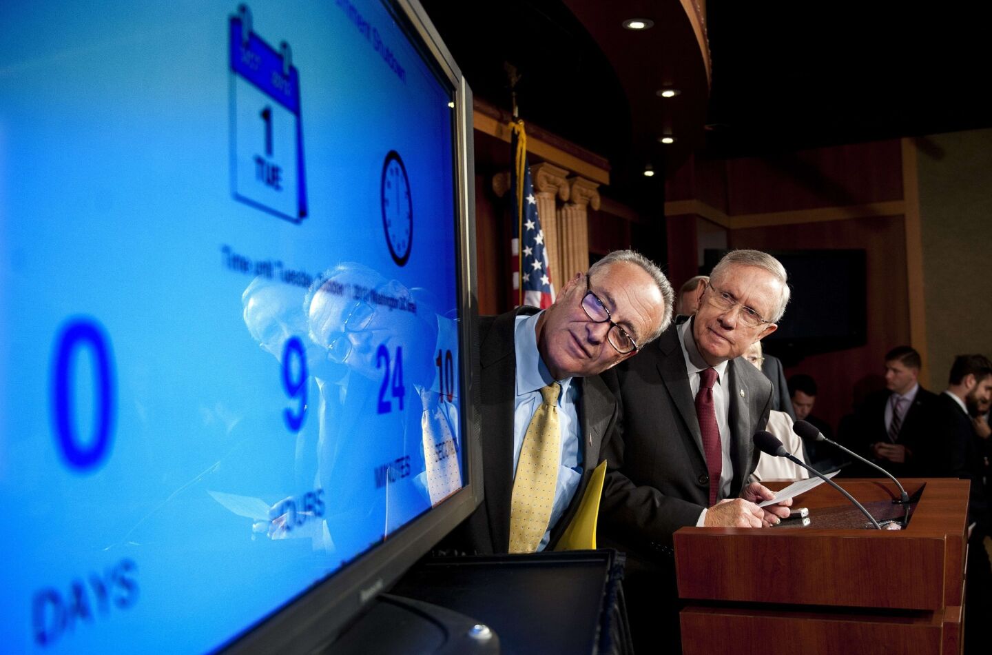Senate Majority Leader Harry Reid (D-Nev.) and Sen. Charles E. Schumer (D-N.Y.), at a news conference, look at a display of the time left until a government shutdown.