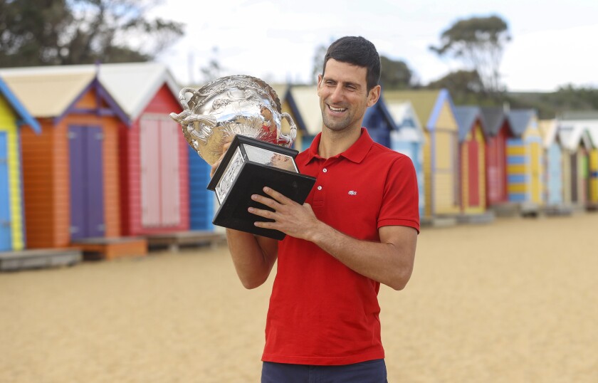 Serbia's Novak Djokovic poses for photos with the Norman Brookes Challenge Cup at Brighton Beach after defeating Russia's Daniil Medvedev on Sunday Feb. 21, 2021 in the men's singles final at the Australian Open tennis championship in Melbourne, Australia, Monday, Feb. 22, 2021.(AP Photo/Hamish Blair)