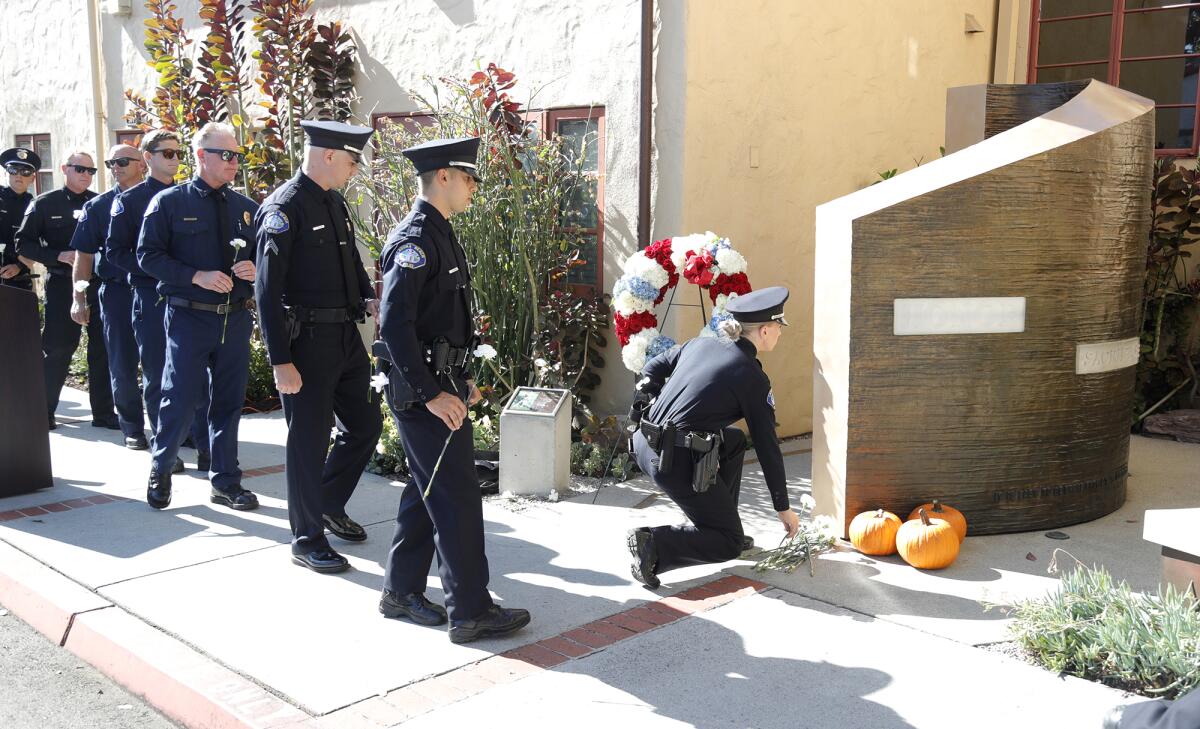 Officers of the Laguna Beach police department lay flowers at the fallen officers memorial wall on Tuesday.