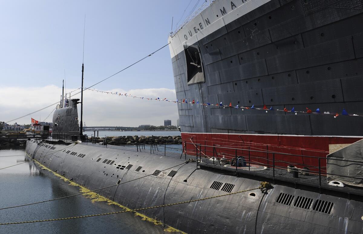 The Russian Foxtrot-Class submarine known as the Scorpion sits next to the Queen Mary.