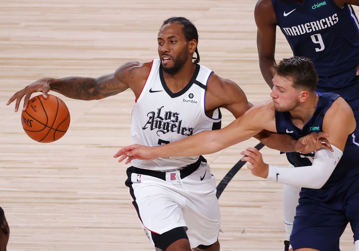 Dallas Mavericks guard Luka Doncic fouls Clippers forward Kawhi Leonard during their first-round playoff series in August.