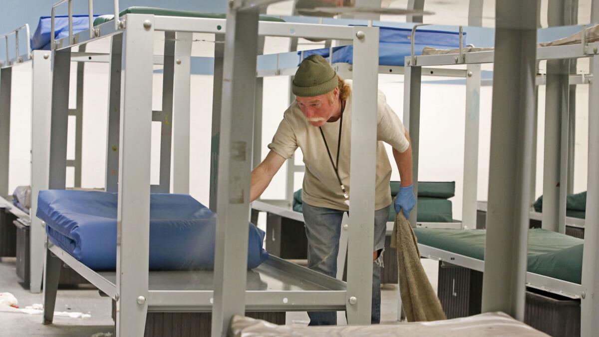 A worker cleans beds in the men's section of the Road Home shelter in Salt Lake City. The shelter serves as many as 1,100 homeless people on busy nights.