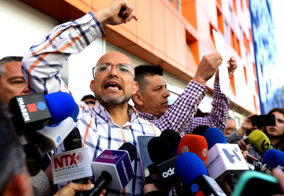 Israel Rivas, left, and Omar Hernandez address the media during a protest Tuesday outside the Children's Hospital in Mexico City.