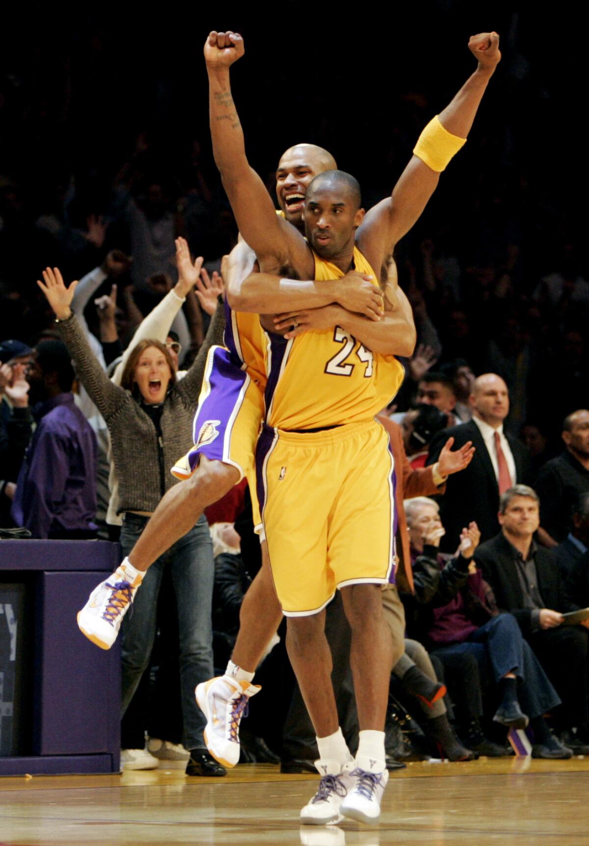 Derek Fisher leaps onto the back of teammate Kobe Bryant after he made a game-winning, last-second shot against the Heat.