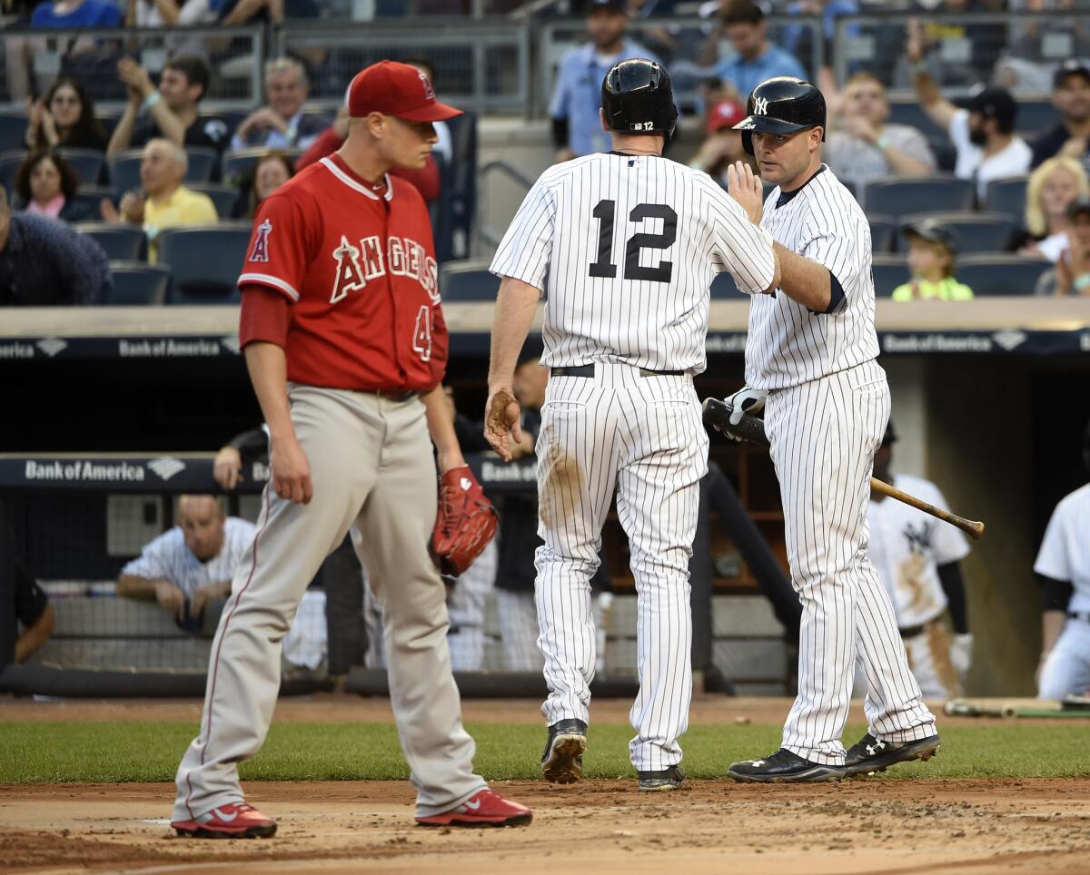 El abridor de los Angels, Garrett Richards, el reflejo de la derrota, ante el festejo de Chase Headley y Brian McCann, de Yankees.