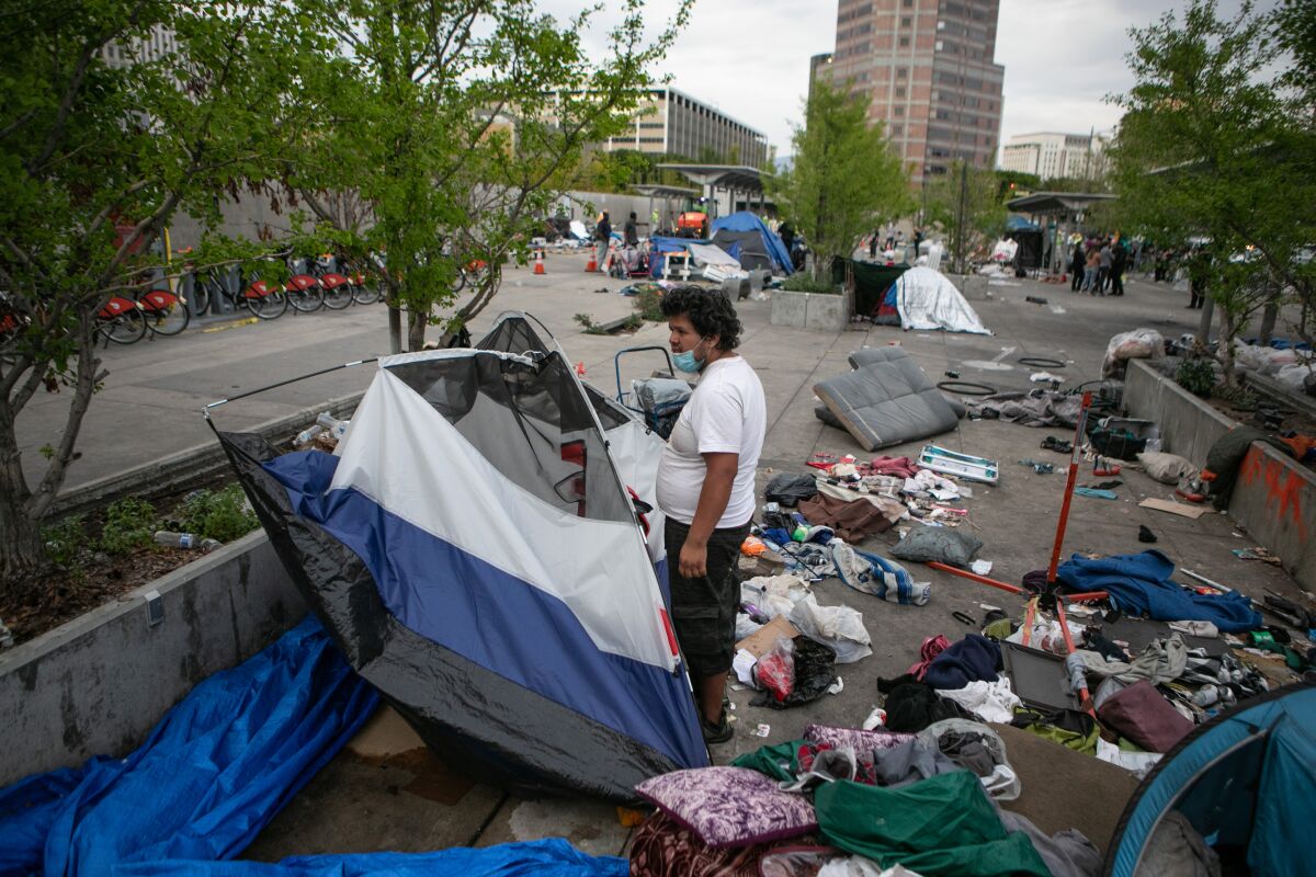 A man packs up his tent as the city of Los Angeles clears Toriumi Plaza in Little Tokyo.