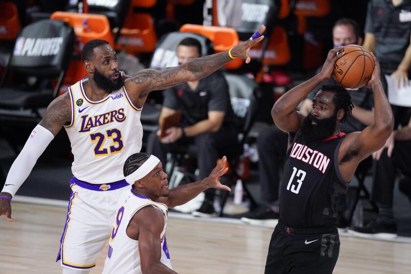Houston Rockets' James Harden (13) passes over Los Angeles Lakers' LeBron James (23) and Rajon Rondo during the first half of an NBA conference semifinal playoff basketball game Tuesday, Sept. 8, 2020, in Lake Buena Vista, Fla. (AP Photo/Mark J. Terrill)