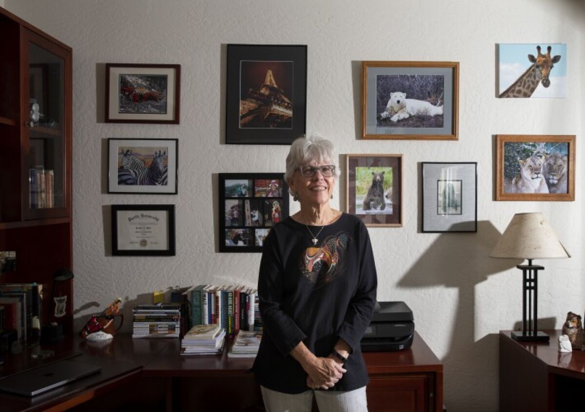 Poet and photographer Debbie Hall is shown in her Escondido home, surrounded by wildlife photographs she has taken. 