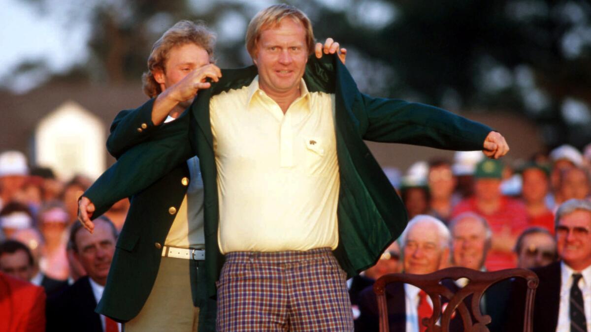 Bernhard Langer helps Jack Nicklaus slip into the winner's green jacket after he triumphed at the Masters in 1986.