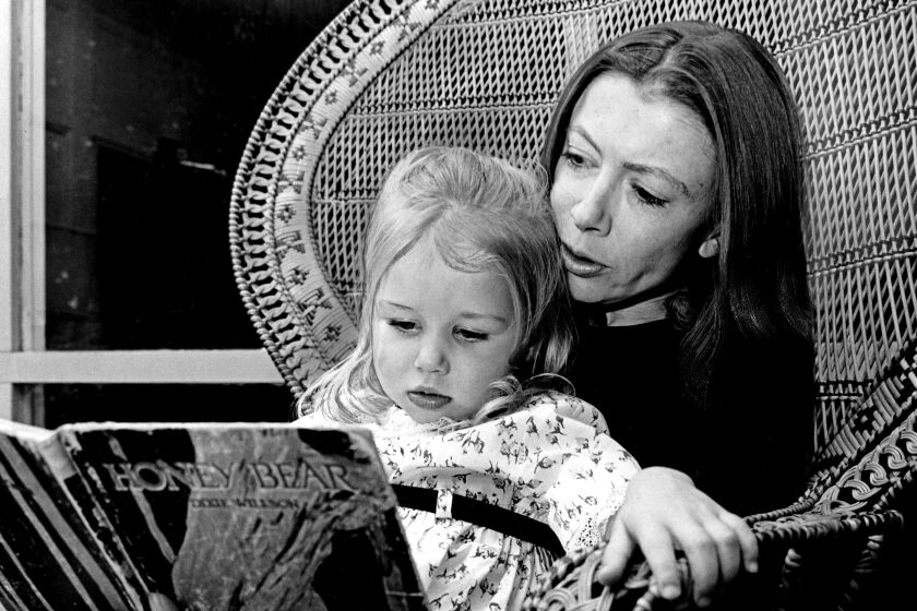 Writer-reporter Joan Didion, a Times Woman of the Year for 1968, reads her daughter Quintana, 2-½. Her husband, John Gregory Dunne, also a writer, and she have just completed a screenplay. Published Jan. 1, 1969. (Cal Montney / Los Angeles TImes)