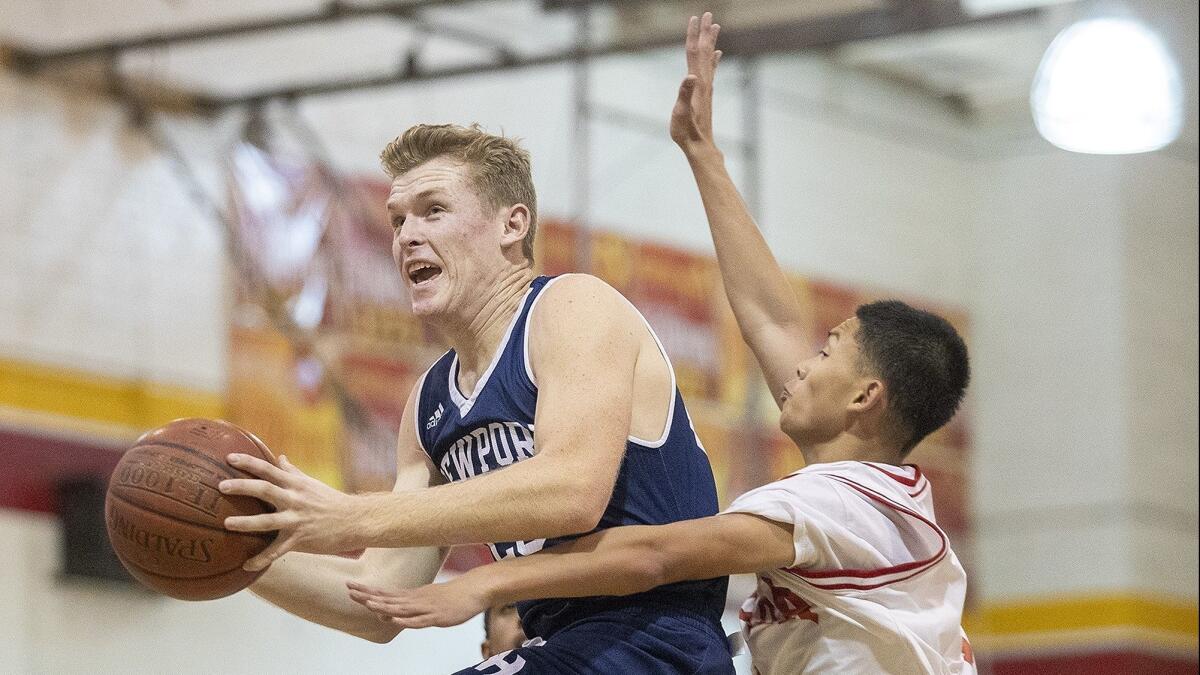 Newport Harbor High's Sam Barela drives to the basket past Loara's Dakota Nanthavongdouangsy in a Grizzly Invitational opener on Nov. 27.