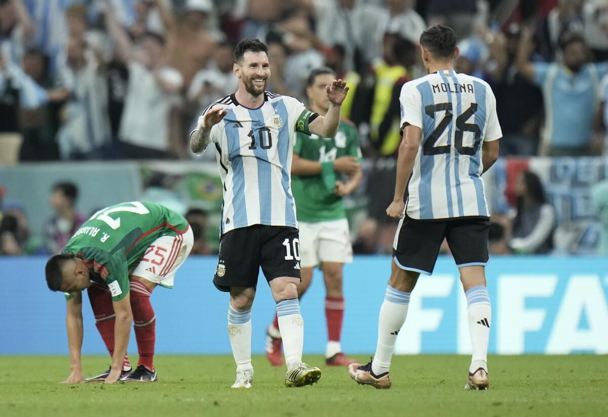 Argentina's Lionel Messi (10) celebrates with Nahuel Molina after a 2-0 win over Mexico in the World Cup on Nov. 26, 2022.