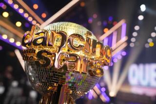 The "Dancing with the Stars" mirrorball trophy glistens under a spotlight.