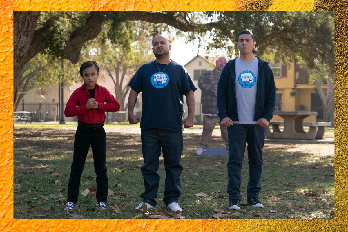 Two men and a young man standing in a row, ready to fight