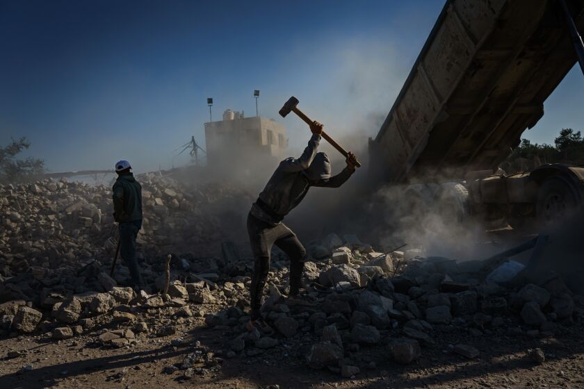 GAZA CITY, PALESTINIAN TERRITORY -- MAY 29, 2021: Workers with sledgehammer engage in a Sisyphean task: breaking up bigger pieces of rubble before they're fed into the crusher, in an area on the Israeli-Gaza border, in Al-ShujaOiya, east Gaza, Saturday, May 29, 2021. (MARCUS YAM / LOS ANGELES TIMES)