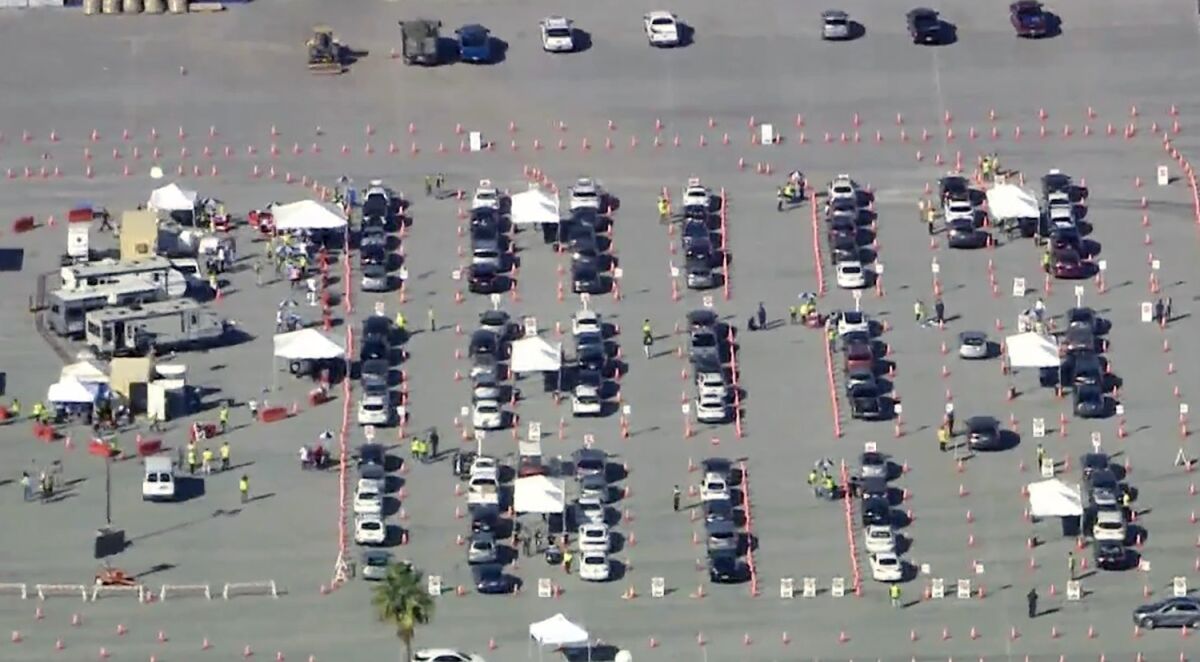 An aerial view of cars in a parking lot alongside tents and trailers.