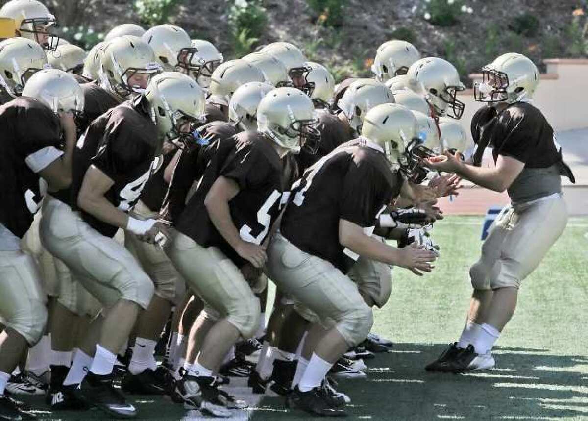 The St. Francis varsity football team congregates in the end zone to get fired up at preseason practice.