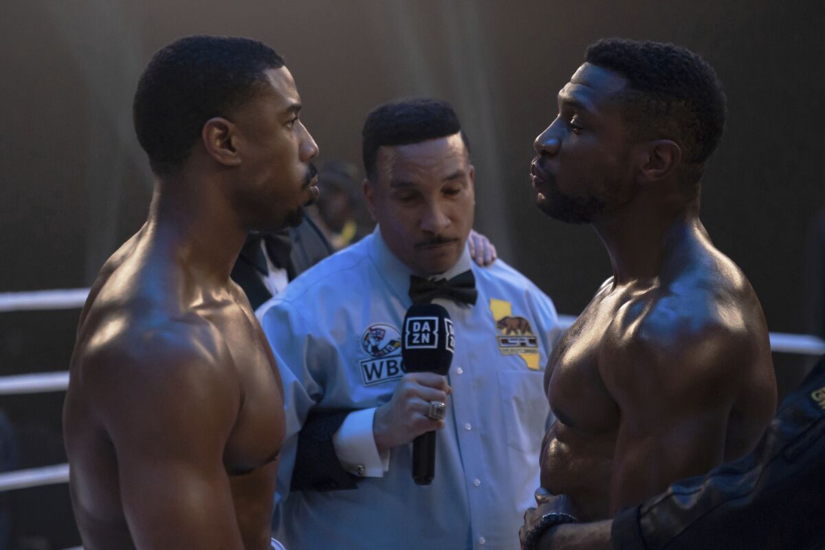 two boxers face each other with an announcer between them