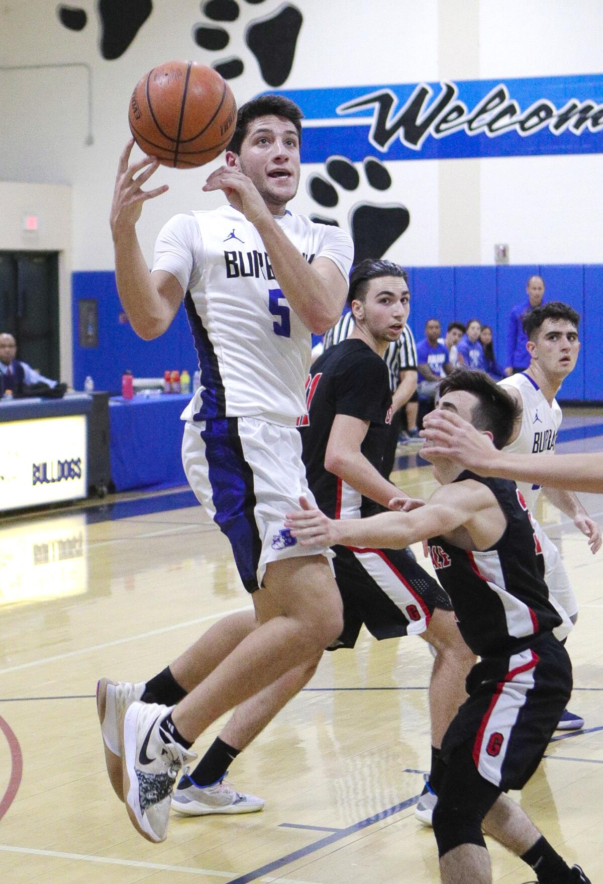 Burbank's Ben Burnham drives and hangs in the air to shoot as the ball gets out of his control in the paint against Glendale in a Pacific League boys' basketball game at Burbank High School on Friday, January 17, 2020.