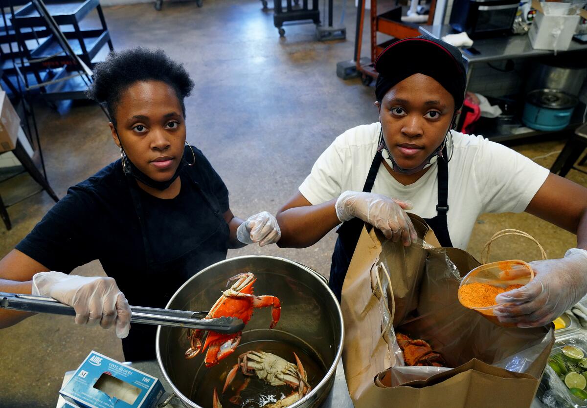 LaShone and RaeShawn Middleton stand side by side, their arms full of kitchen supplies