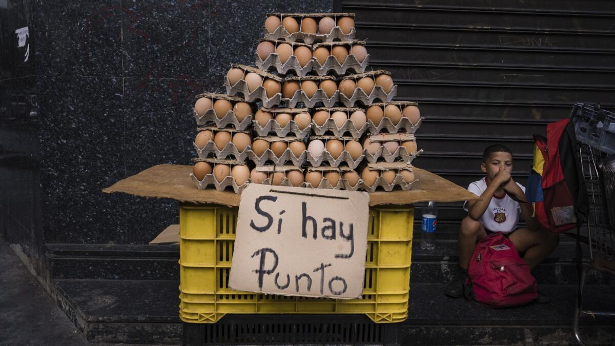 A Caracas street stand selling eggs displays a sign saying debit cards are accepted. Even small purchases are regularly paid with a debit or credit card due to cash shortages.