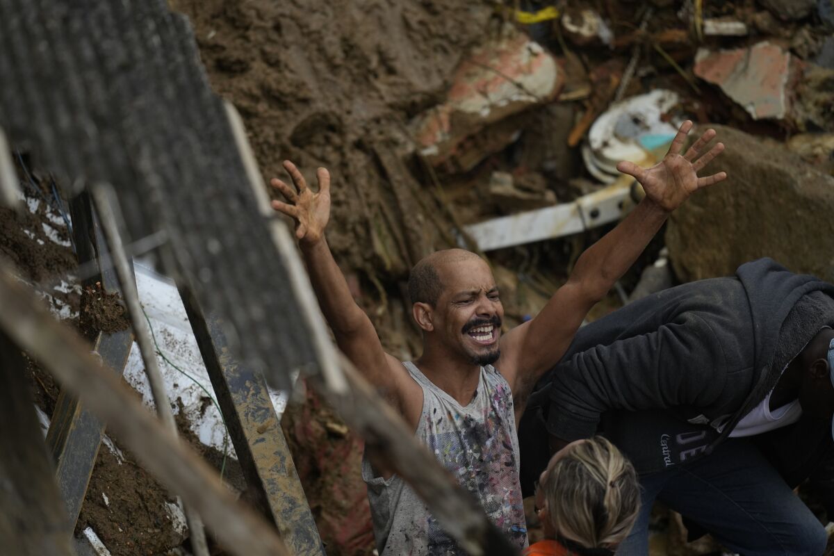 A resident yells during the search for survivors after fatal mudslides in Petropolis, Brazil, Wednesday, Feb. 16, 2022. Extremely heavy rains set off mudslides and floods in a mountainous region of Rio de Janeiro state, killing multiple people, authorities reported. (AP Photo/Silvia Izquierdo)