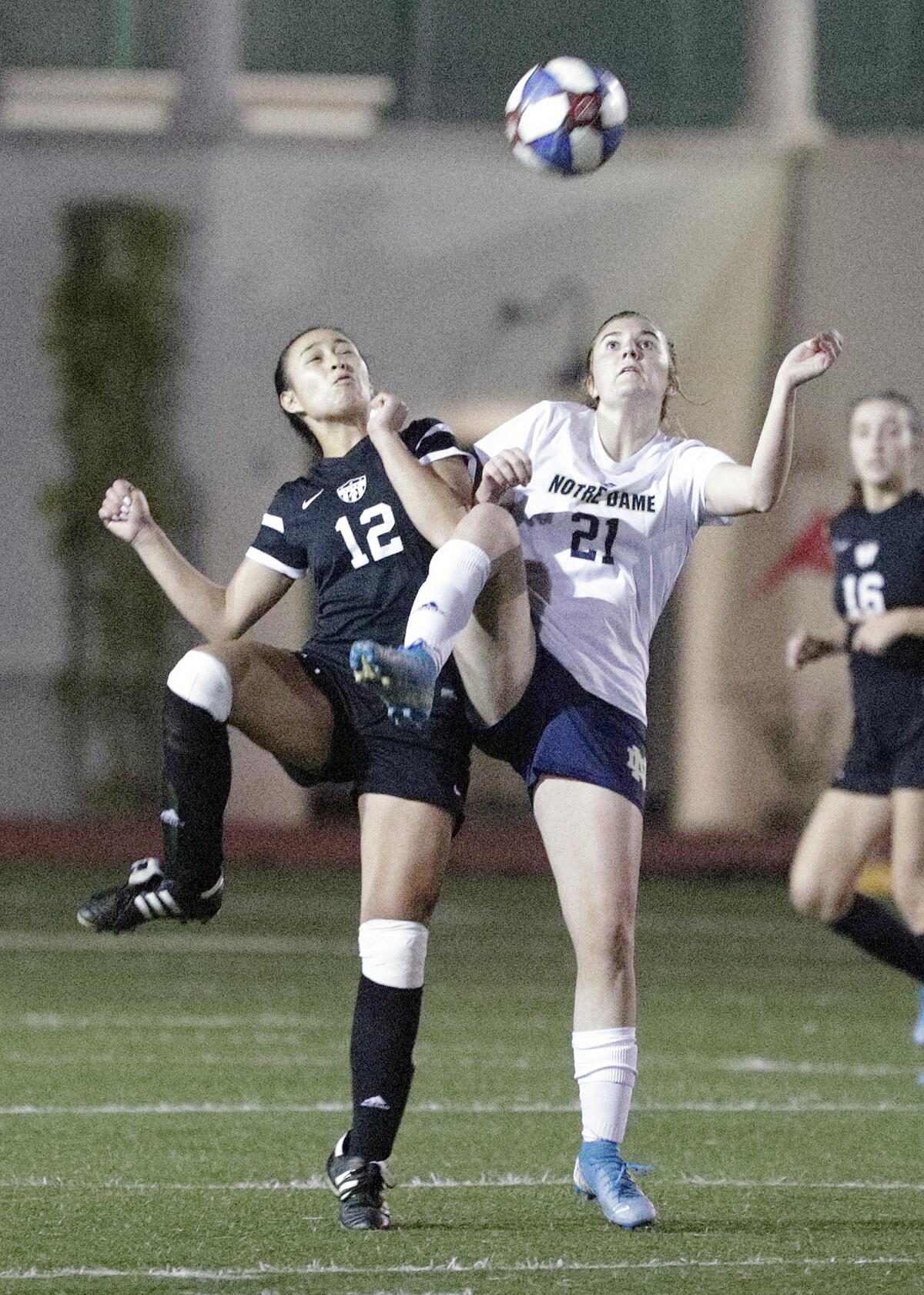 Flintridge Sacred Heart's Therese Daniels and Sherman Oaks Notre Dame's Mia Richardson reach to control the ball in a Mission League girls' soccer game Wednesday at Occidental College.