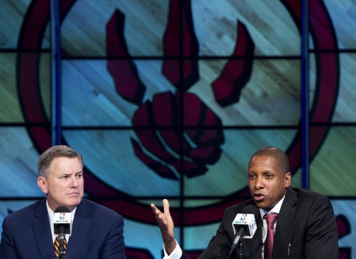 Tim Leiweke, left, listens as new Raptors general manager Masai Ujiri speaks during a news conference.