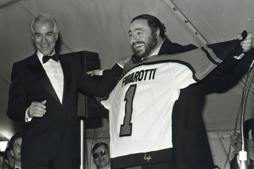 FILE - In this March 15, 1985 file photo, tenor Luciano Pavarotti shows off the Philadelphia Flyers jersey presented to him by Flyers owner Ed Snider, left, after a concert by Pavarotti at the Spectrum in Philadelphia. Ed Snider, the Philadelphia Flyers founder whose "Broad Street Bullies" became the first expansion team to win the Stanley Cup, died Monday, April 11, 2016 after a two-year battle with cancer. He was 83. (AP Photo/Amy Sancetta, File)