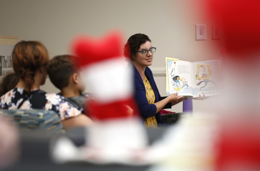 A librarian reads a Dr. Seuss book to a group of children.