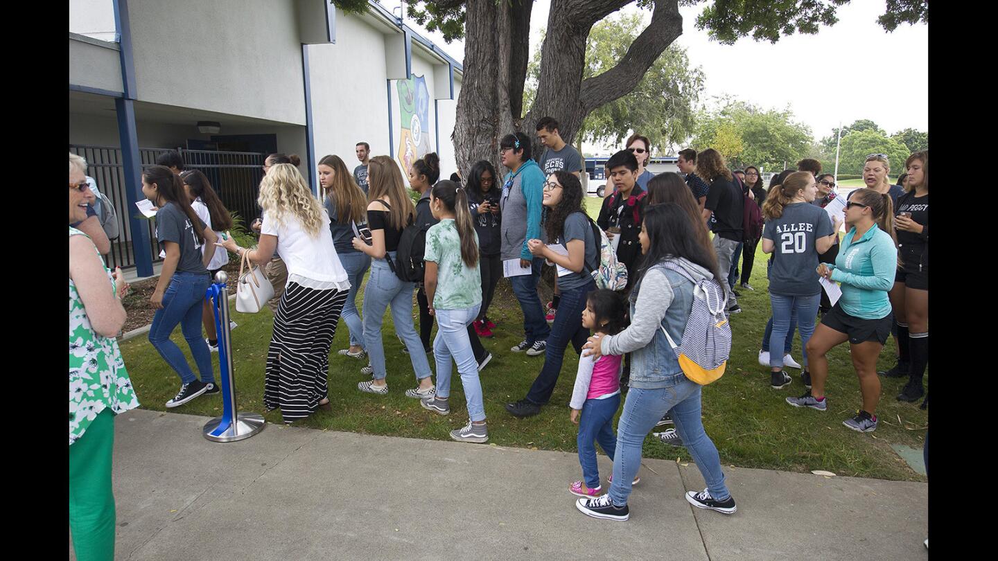 Early College High School students pour into campus through a new gate and fence after the ribbon-cutting ceremony at Early College High School on Wednesday.