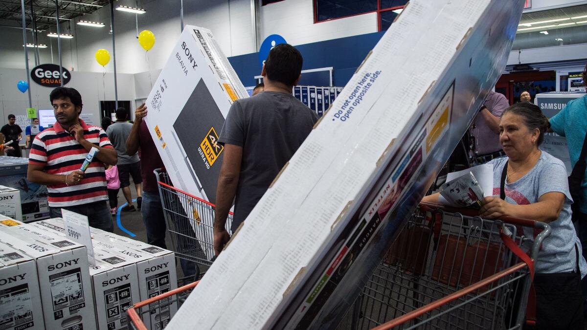 The aisles are gridlocked as customers maneuver shopping carts filled with large flat screen TVs at Best Buy in Atwater Village.