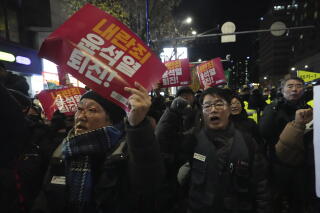 Protesters march and hold up signs.