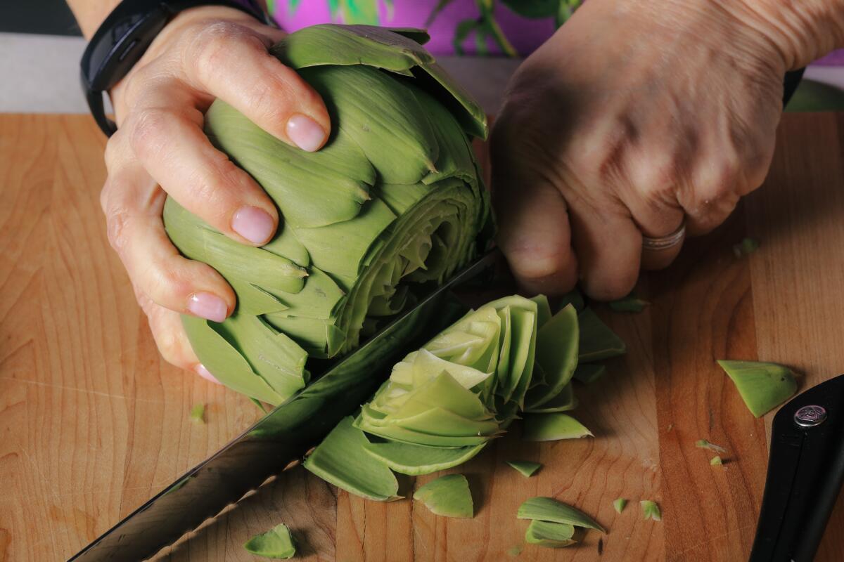 Start trimming an artichoke by cutting off the top third of the leaves.