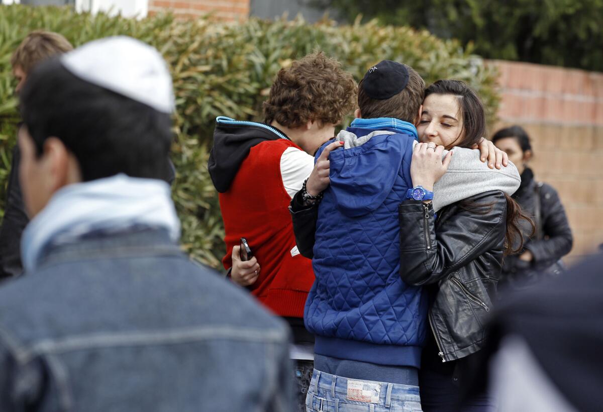 Students comfort each other at the Ozar Hatorah Jewish school where a gunman opened fire killing four people in Toulouse, southwestern France.