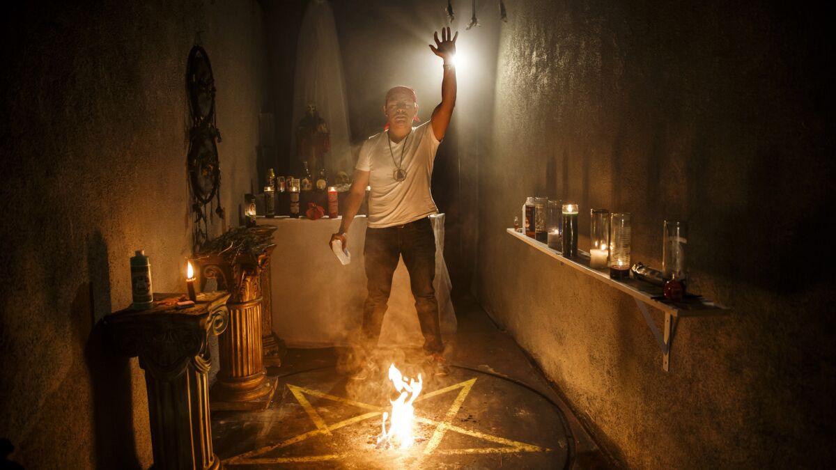 Mateo Chavarria performs a spiritual cleansing of his work area, at the Botanica De Los Angeles.