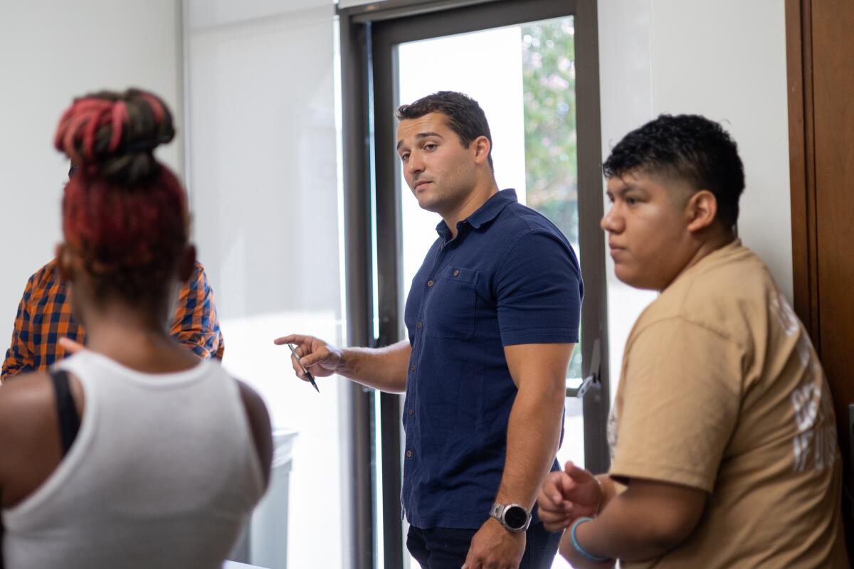 Four college students talking in a classroom