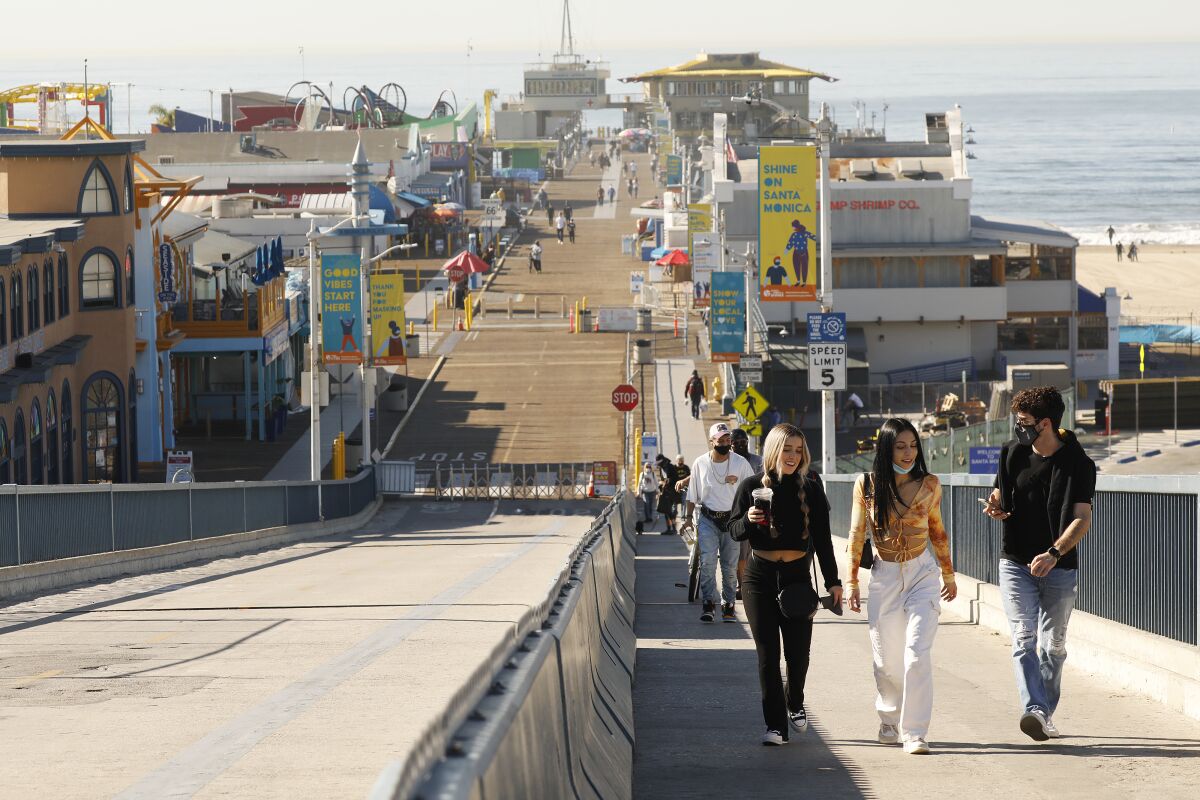 Young people walk near the beach and shops.