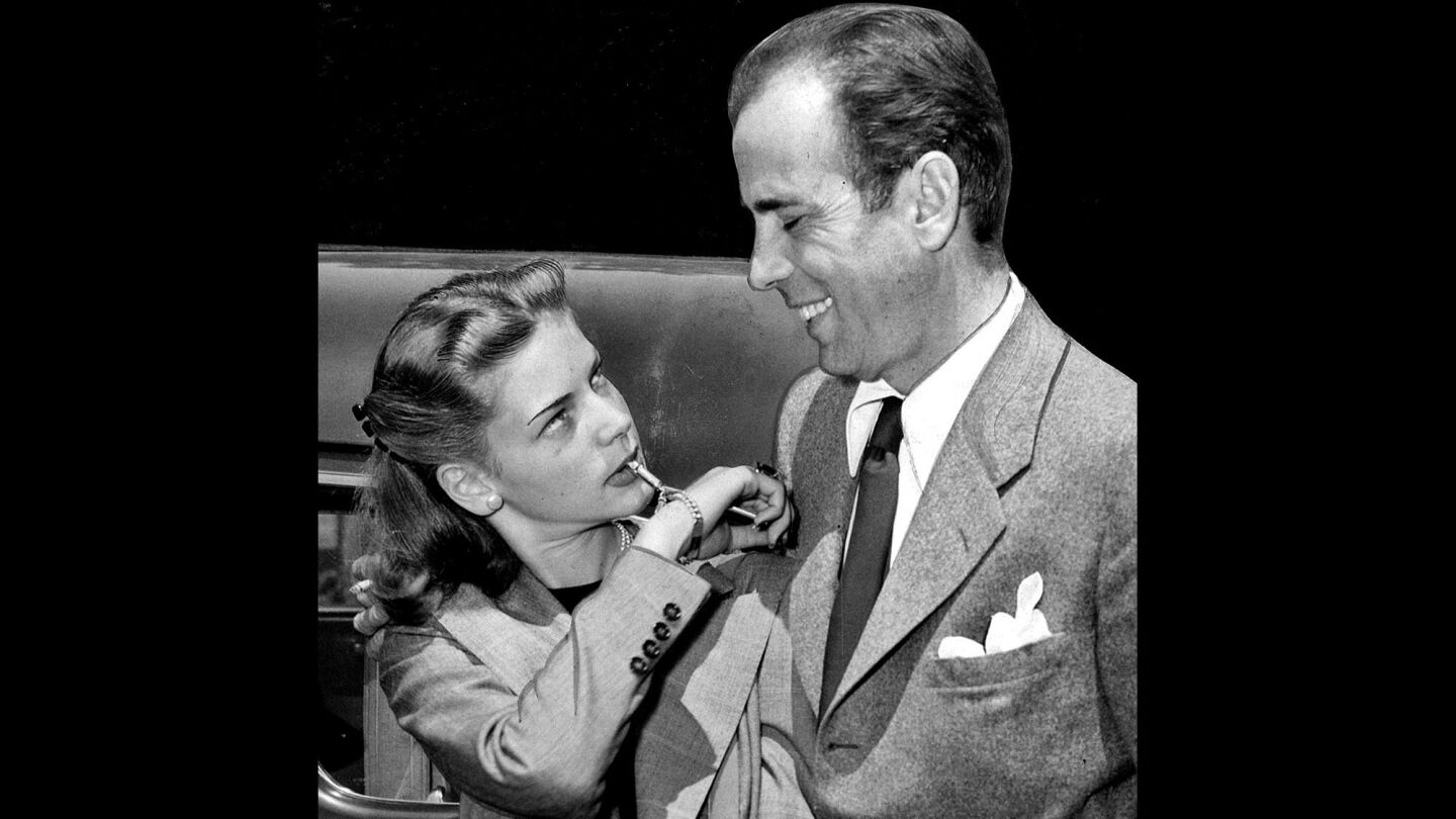 Bacall and Bogart arrive at Los Angeles' Union Station upon their return to California after wedding in Ohio. Bacall is blowing on a small whistle attached to her bracelet.