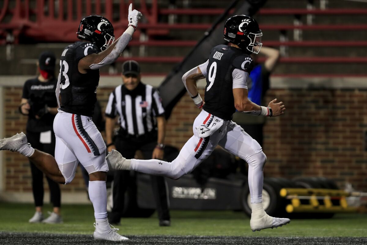Cincinnati running back Gerrid Doaks, left, reacts as quarterback Desmond Ridder, right, scores a rushing touchdown during the second half of an NCAA college football game against Houston, Saturday, Nov. 7, 2020, in Cincinnati. (AP Photo/Aaron Doster)