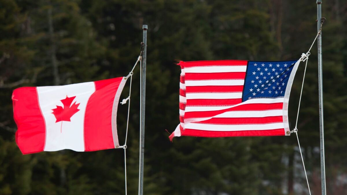 The flags of the U.S. and Canada fly on the border between the two countries in Pittsburg, N.H.