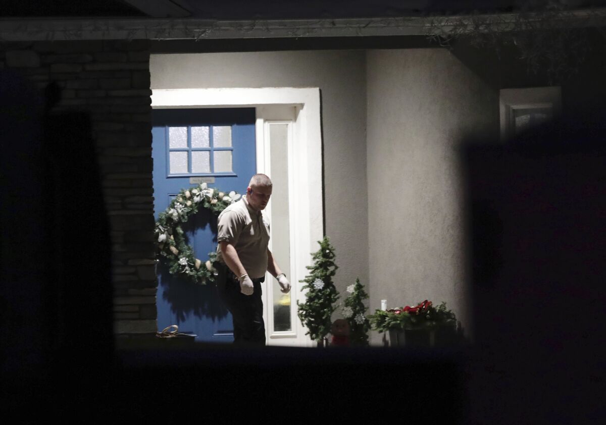 Law enforcement official stands near front door of a Utah home