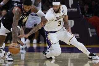 Los Angeles, CA - January 07: Lakers forward Anthony Davis, #3, right, battles Clippers forward Paul George, #13m for control of a loose ball in the second half at Crypto.com Arena in Los Angeles Sunday, Jan. 7, 2024. Lakers beat the Clippers 106-103. (Allen J. Schaben / Los Angeles Times)