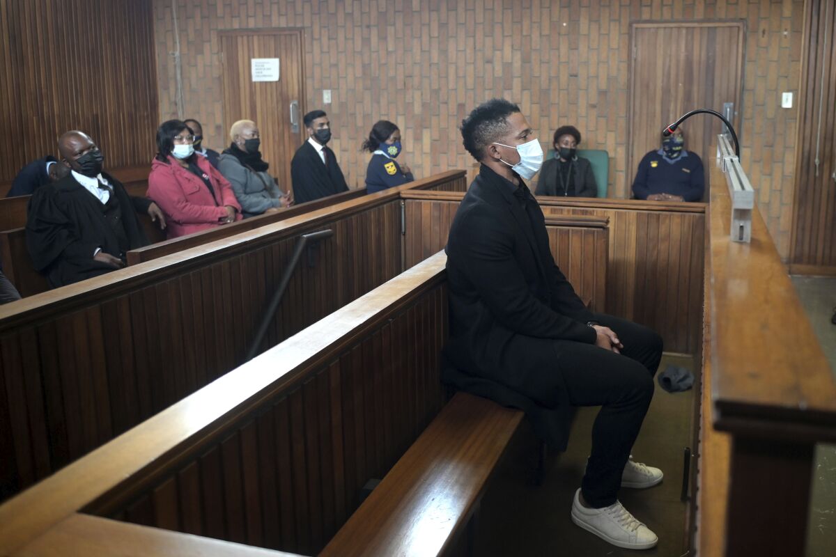 South Africa rugby player Elton Jantjies, center, appears in Kempton Park magistrates court in Johannesburg, Monday, May 16, 2022. Jantjies was arrested for allegedly causing damage to an aircraft during a flight home from a vacation in Turkey. (AP Photo)