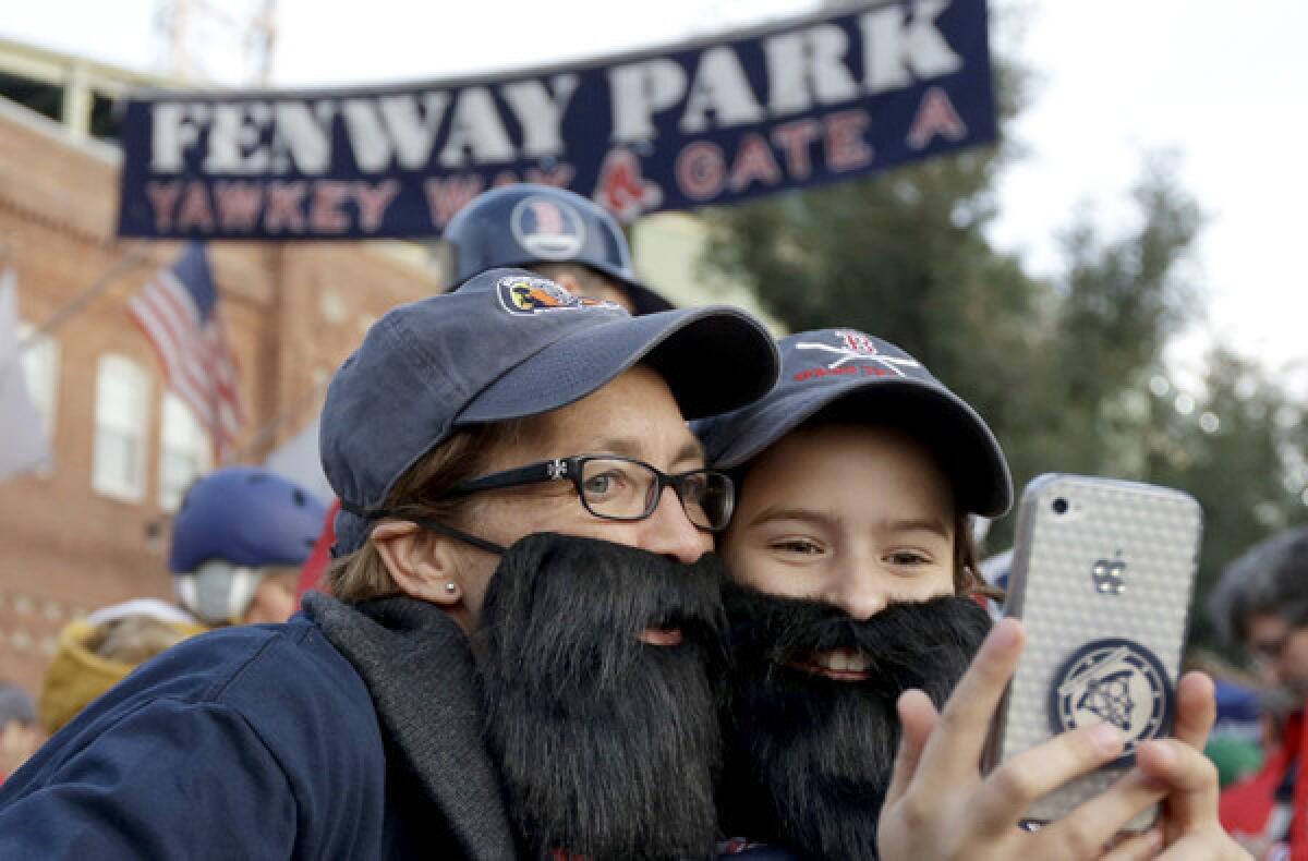 Red Sox fans Lauren Wolf, left, and daughter Norah take a photograph of themselves outside Fenway Park before Game 6 of the World Series on Wednesday evening in Boston.
