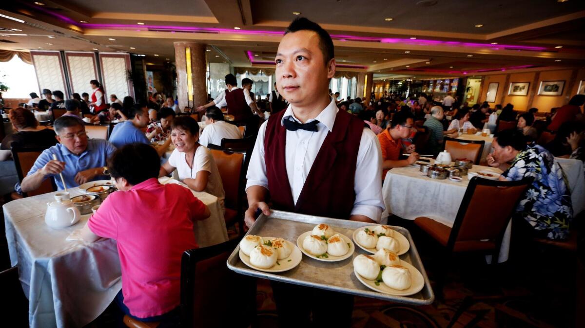 A waiter serves dim sum at Five Star Seafood Restaurant in San Gabriel. Leisure and hospitality businesses added the most jobs in the state last month.