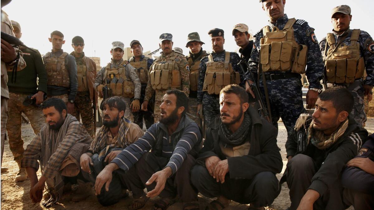Iraqi soldiers and police detain suspects in the village of Salhiya, Iraq. The men were coming from the direction of Mosul.