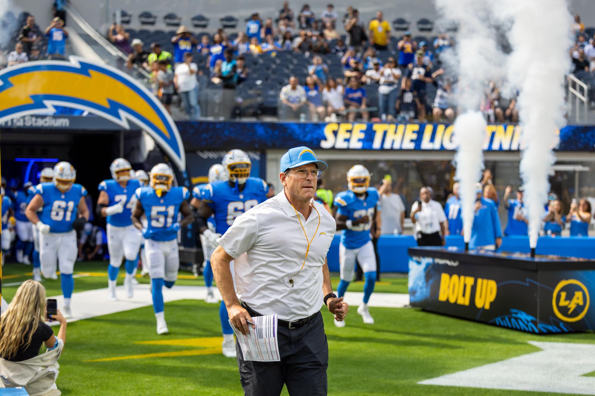 Coach Jim Harbaugh leads his Chargers onto the field at SoFi Stadium.